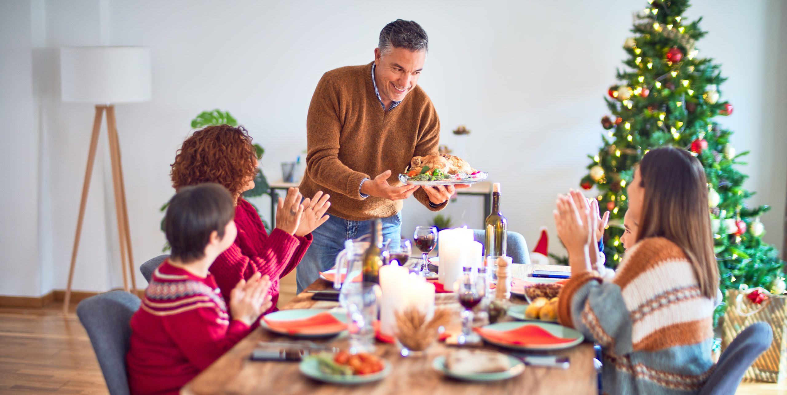 Beautiful family smiling happy and confident. One of them standing showing roasted turkey celebrating christmas at home