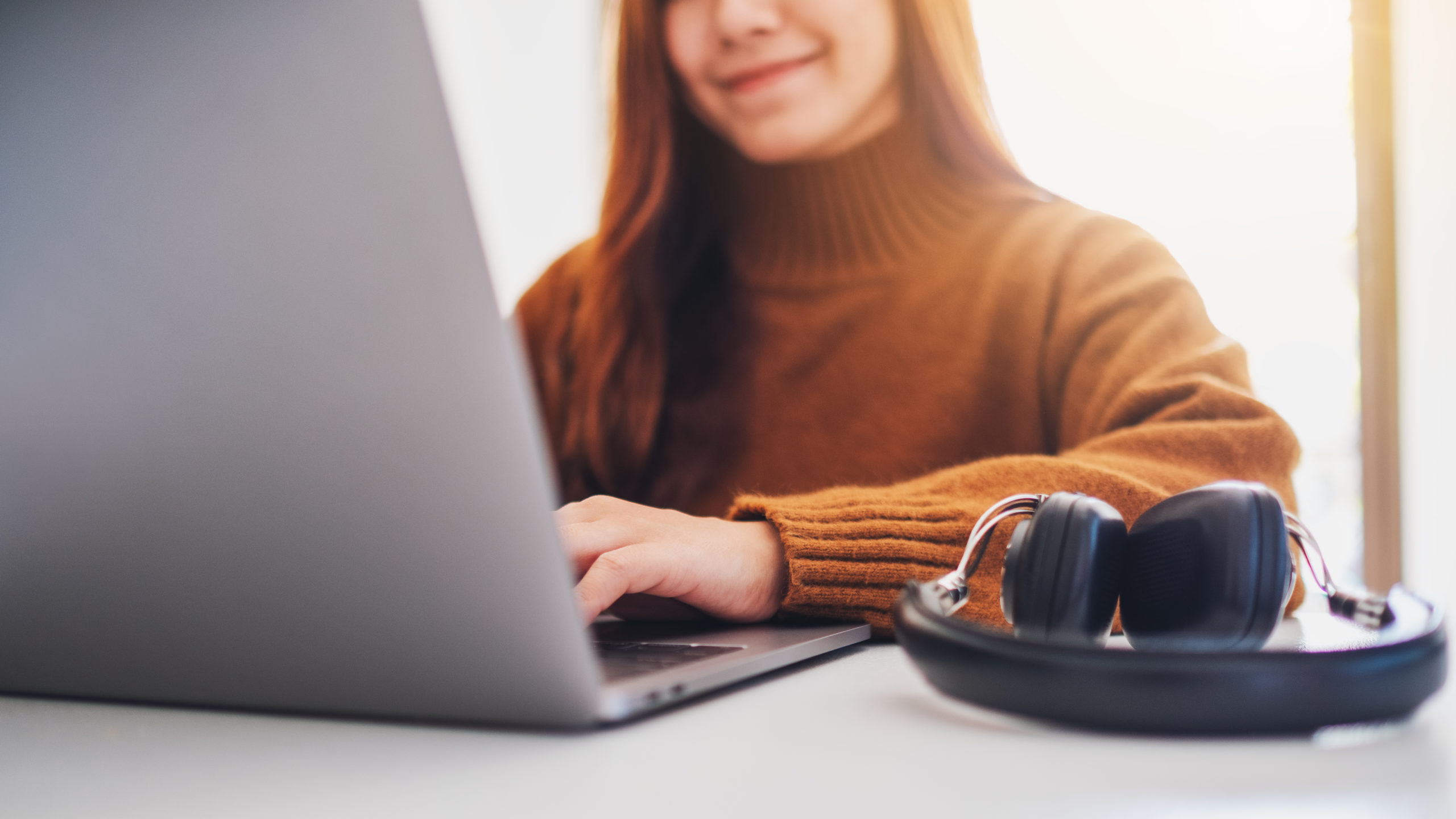 Closeup image of a beautiful woman working and typing on laptop computer in office