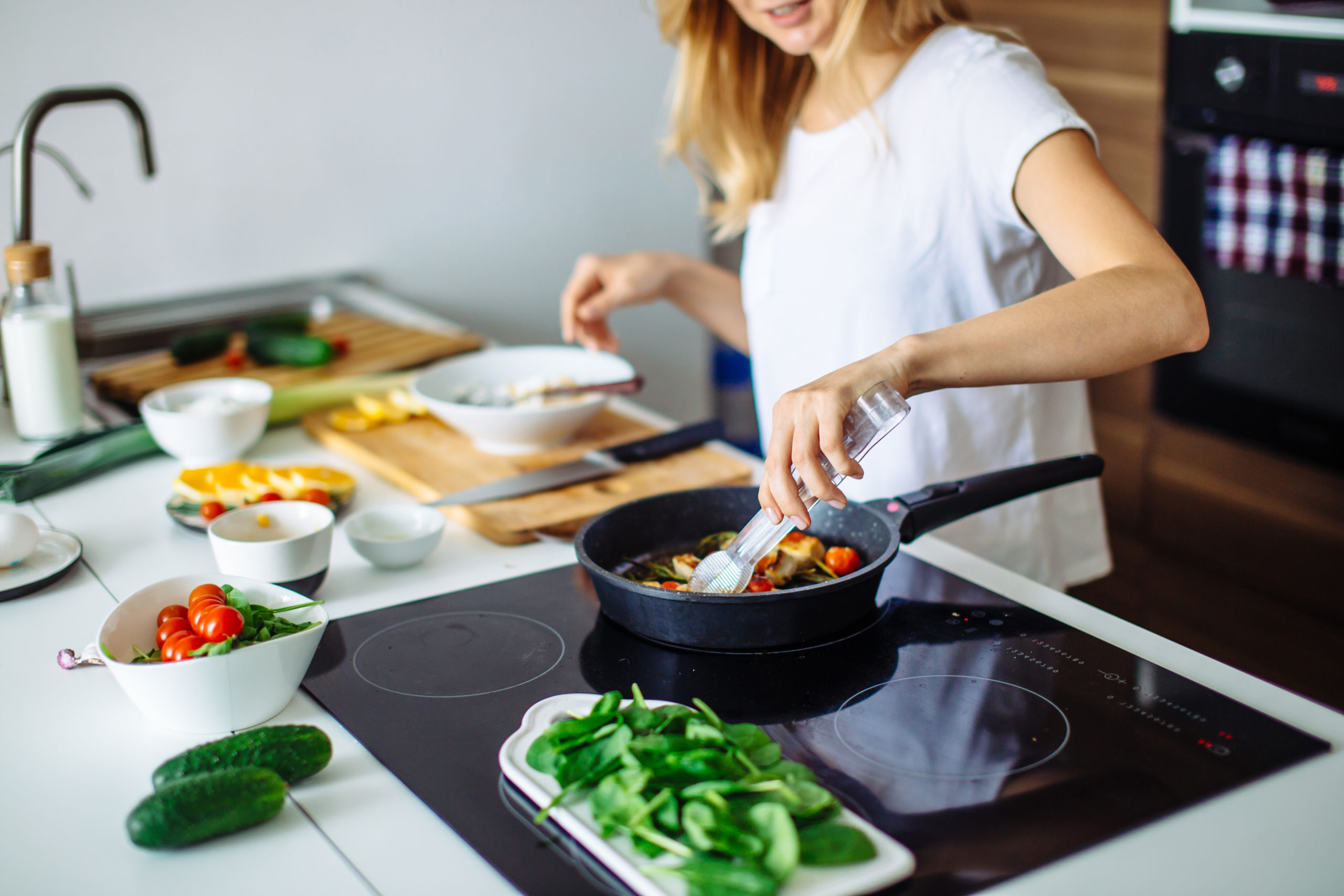 Young blonde woman cooking in the kitchen. Healthy Food. Dieting Concept. Healthy Lifestyle. Cooking At Home. Prepare Food