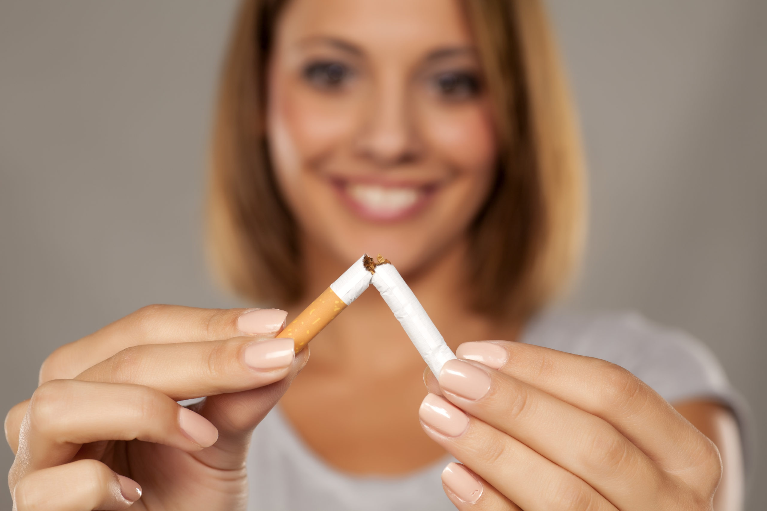 happy young beautiful woman holding a broken cigarette