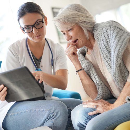 Doctor going through results and medication on tablet with senior patient
